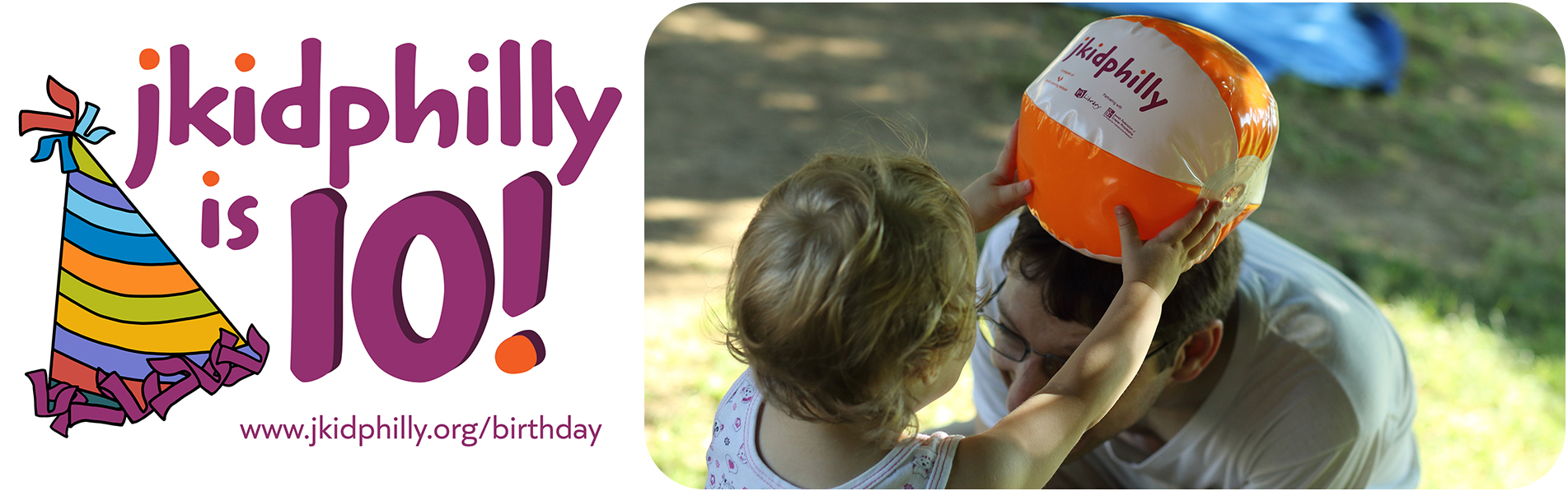 A colorful birthday hat with the words “jkid philly is 10!” written next to it. There is a young child playing with a man in glasses, as he bends down to be eye level with the girl, she playfully puts an orange and white ball on his head.