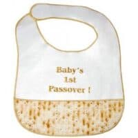 An image of a baby bib with matzah print that says Baby's 1st Passover