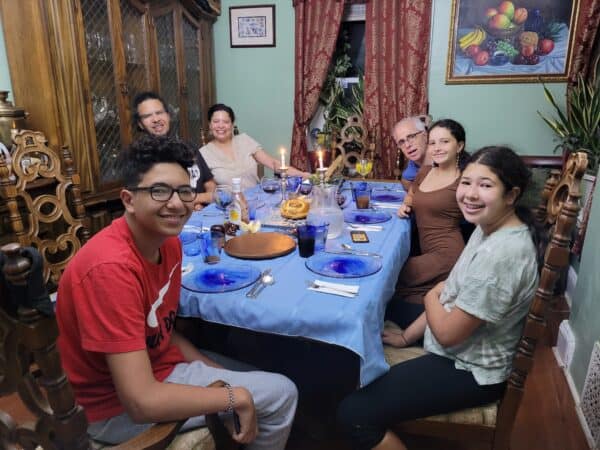 A photo of a large family sitting around a dinner table together.