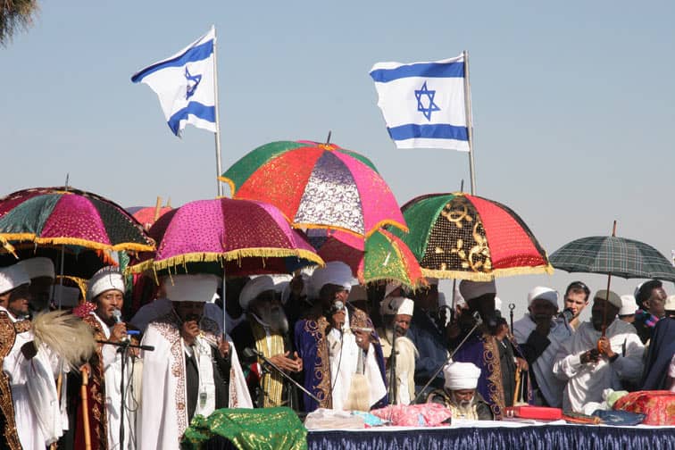 A photo of people with colorful umbrellas standing in the sun